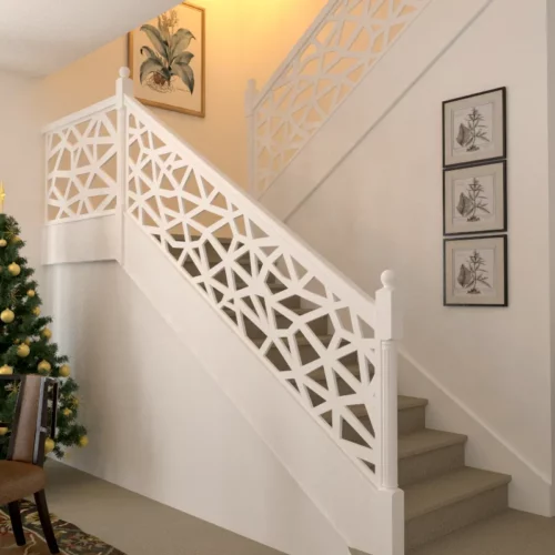Staircase with geometric pattern railing and a decorated Christmas tree.